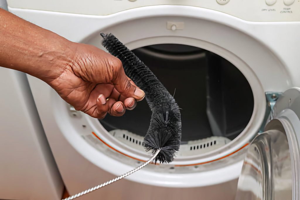 a black man cleaning out a dryer vent with a brush a black man cleaning out a dryer vent with a brush